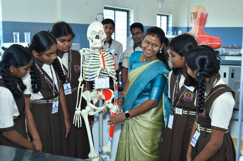 Biology teacher explaining human skeletal structure system to students