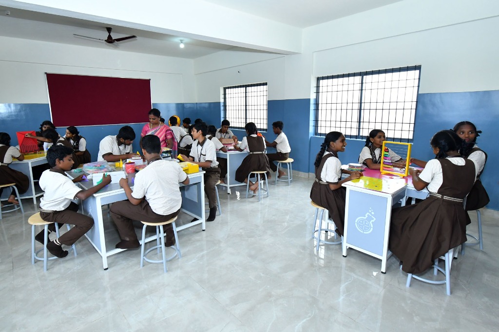 Primary students working in mathematics laboratory with abacus and geometric tools
